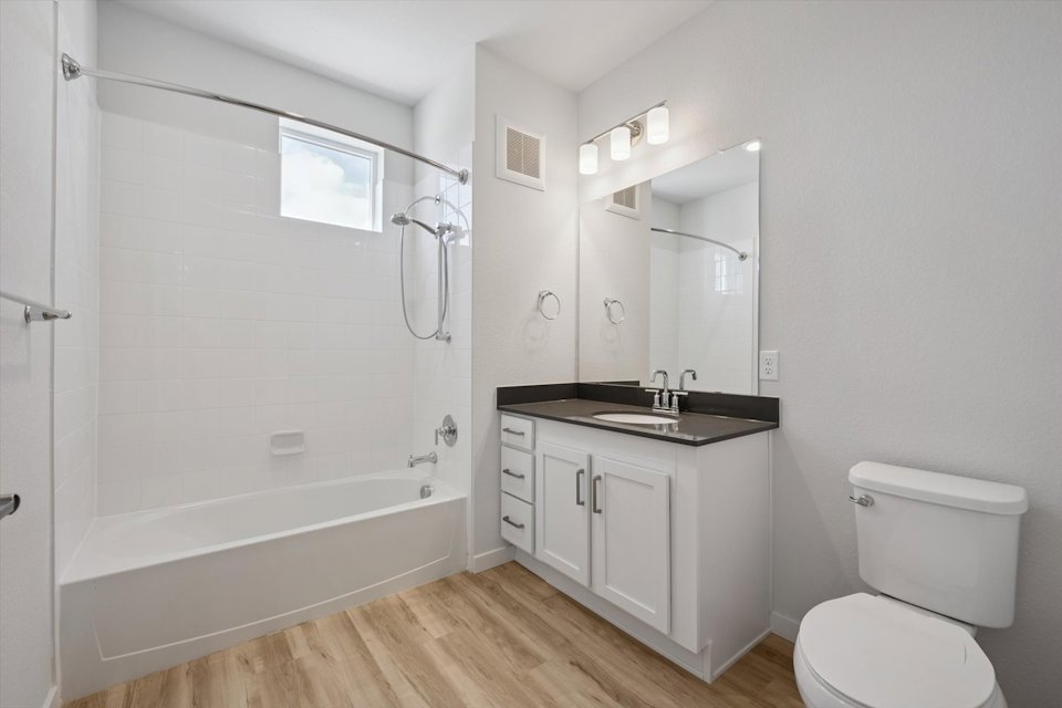 A bathroom with a tub toilet and sink.