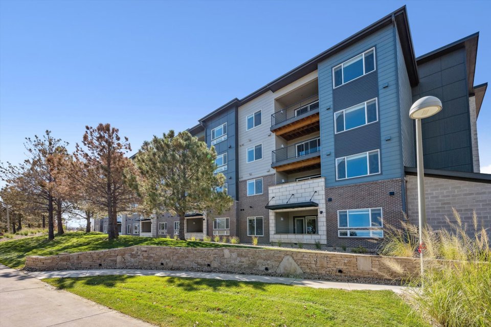 A building with a lawn and trees.
