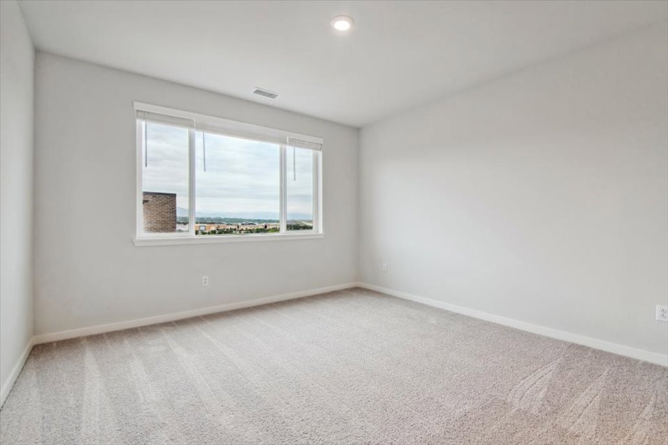 A room with a window and a rug.