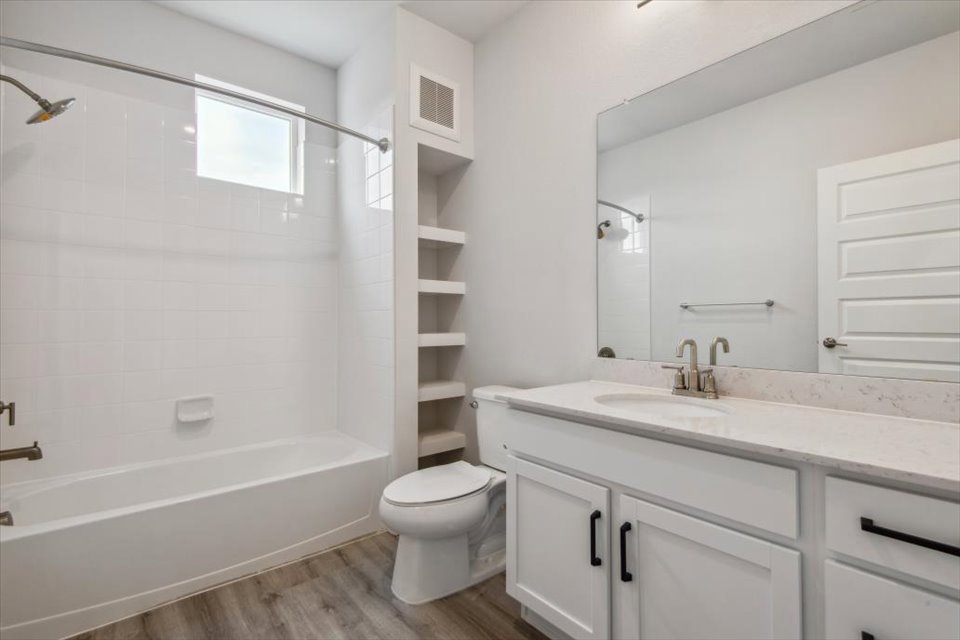 A bathroom with a white bathtub and a toilet.