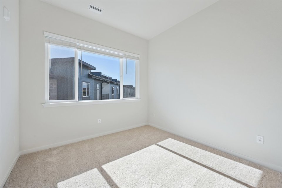 A room with a window and a rug.