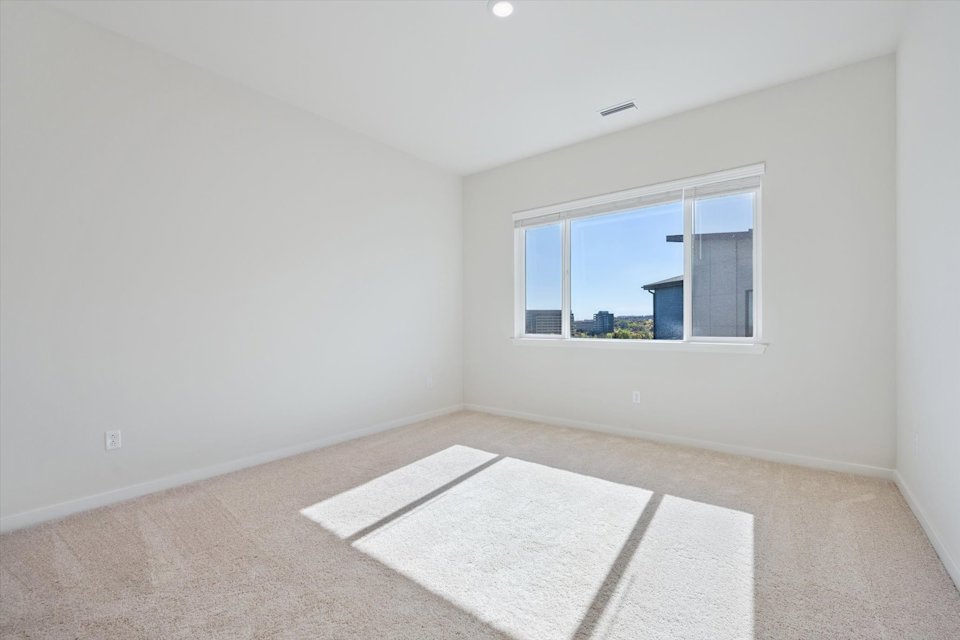 A room with a rug and a window.