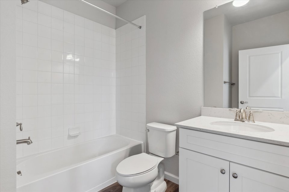 A bathroom with a tub sink and toilet.