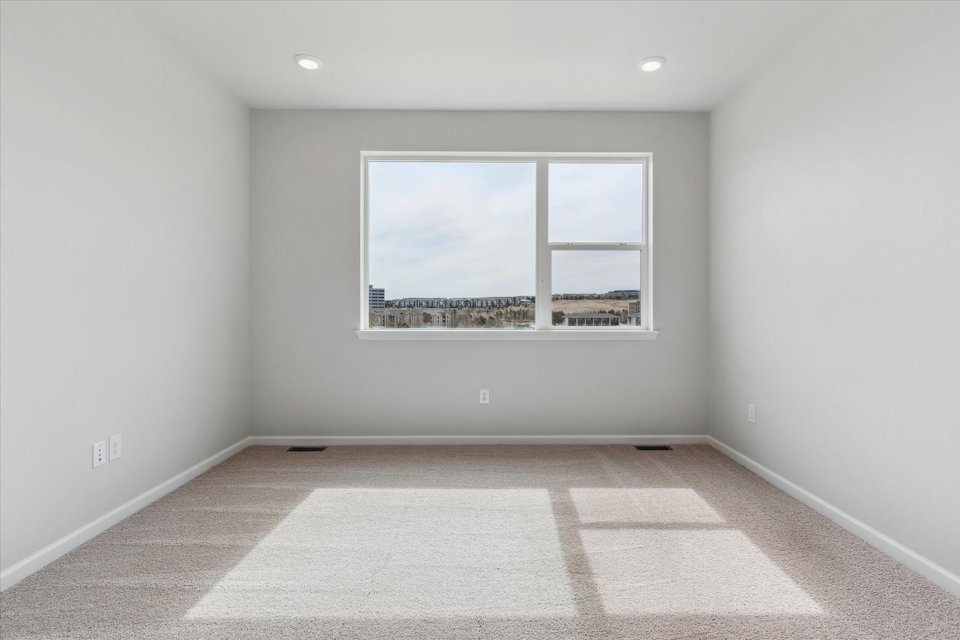 A room with a window and a view of a city.