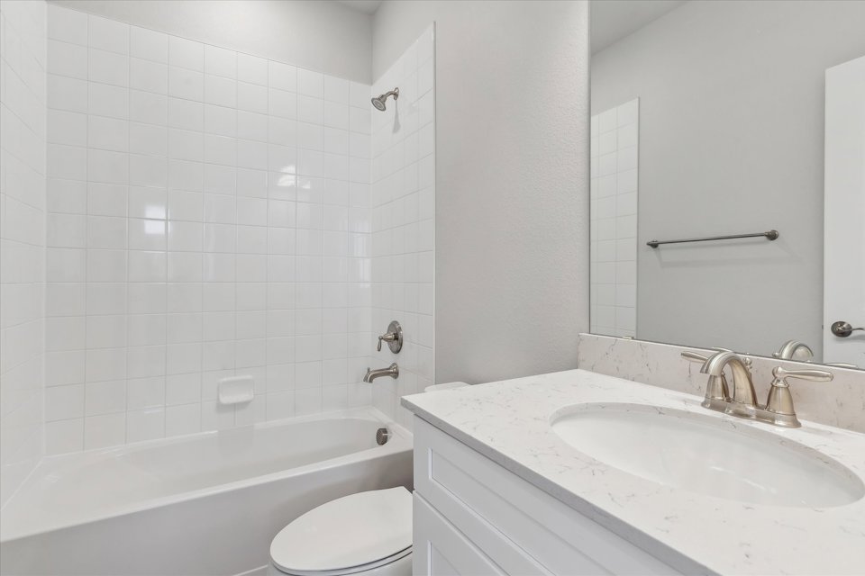A bathroom with a tub sink and toilet.