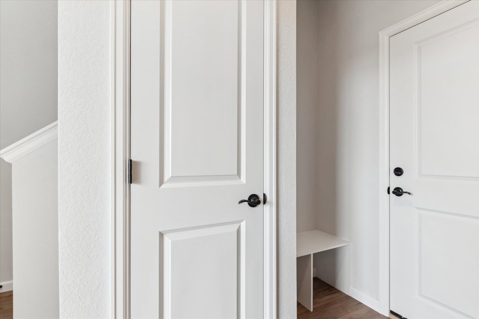 A white door with a chair in the background.