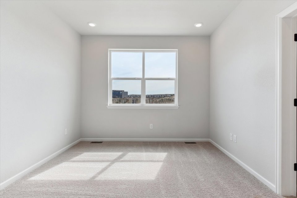 A room with a window and a rug.