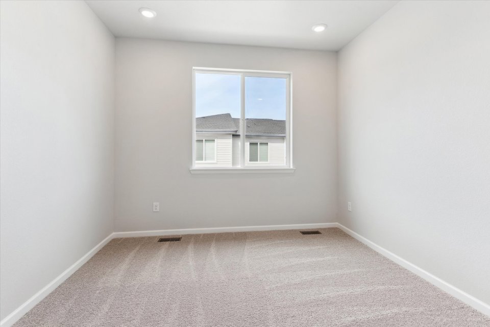 A room with a window and a white wall.