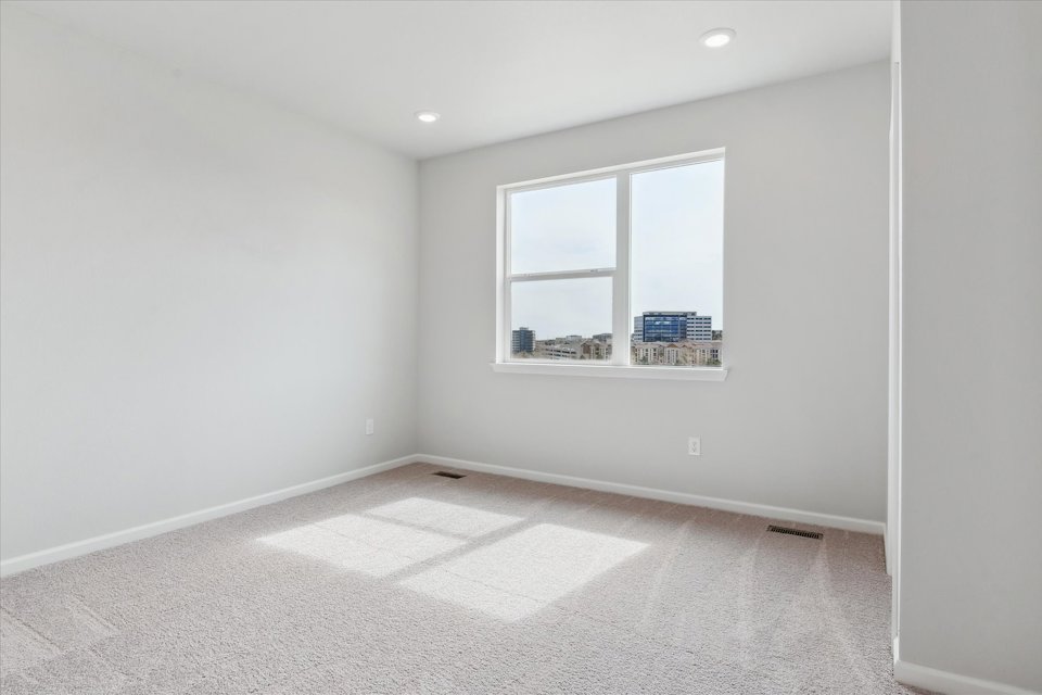 A room with a window and a rug.