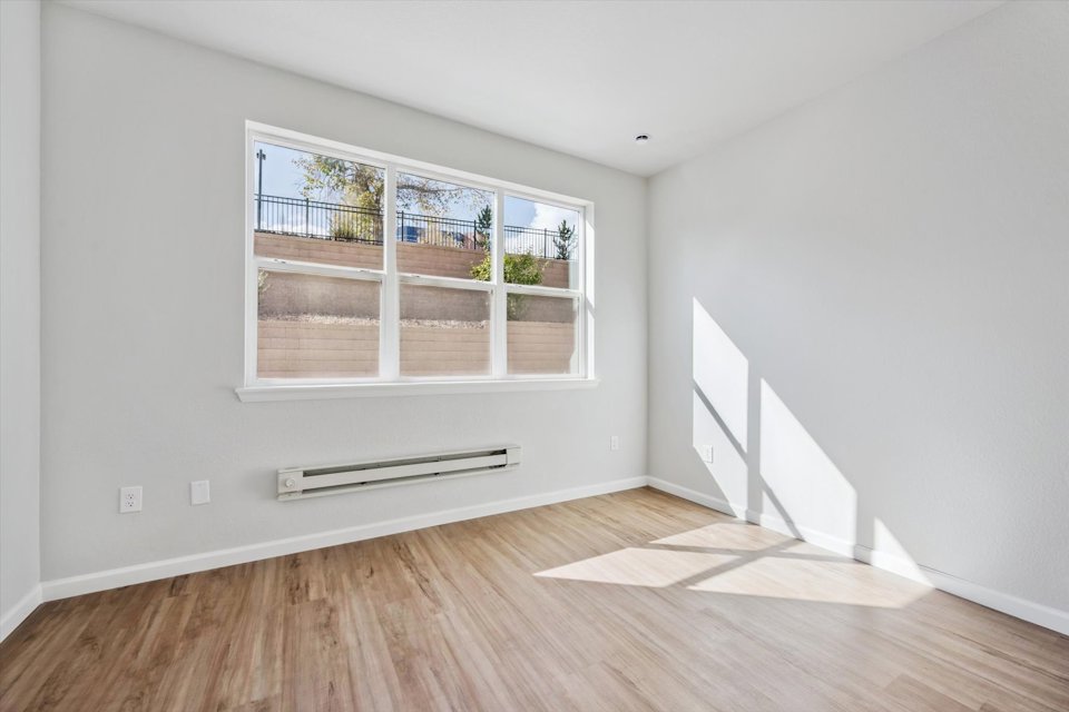 A room with a window and a wood floor.