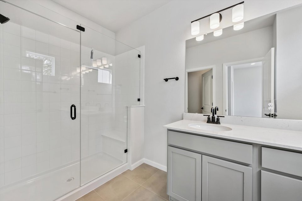 A bathroom with a sink and shower.