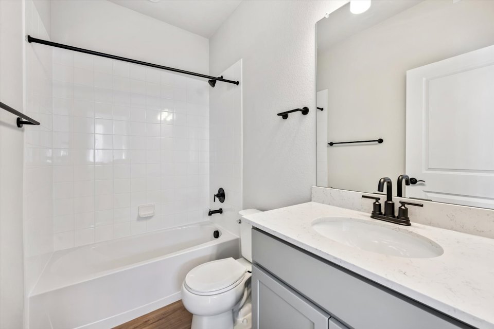 A bathroom with a tub sink and toilet.