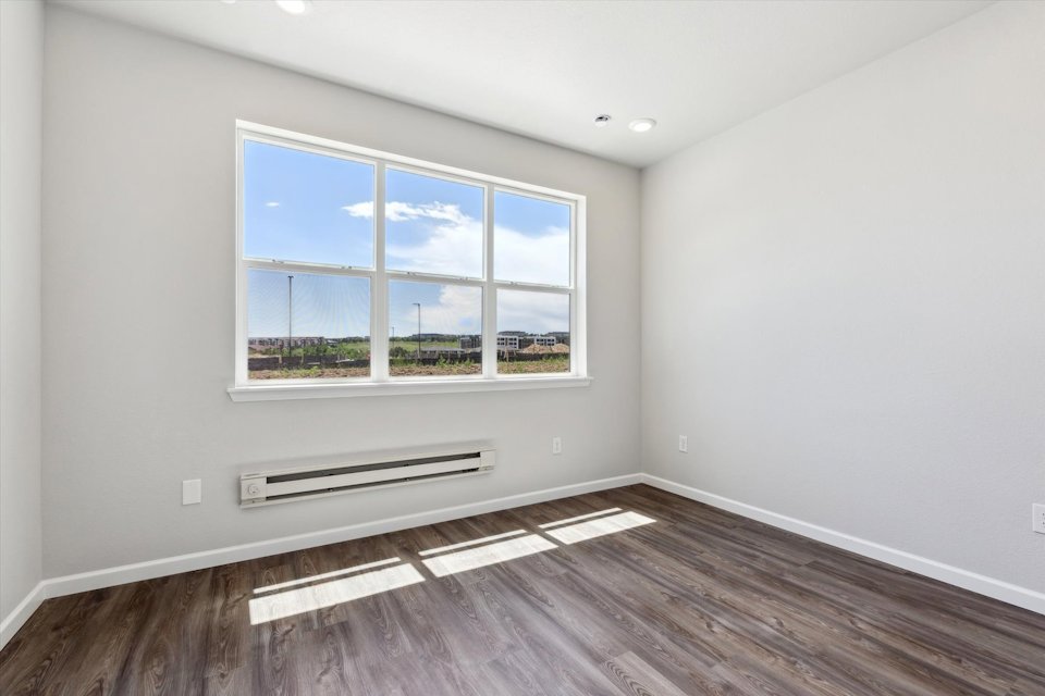 A room with a window and a wood floor.