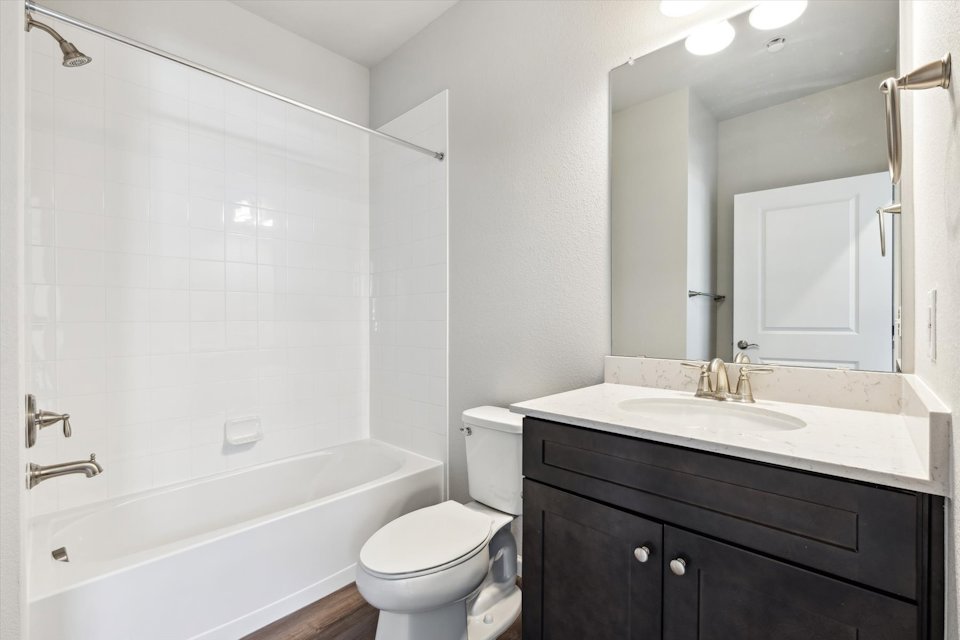 A bathroom with a tub sink and toilet.