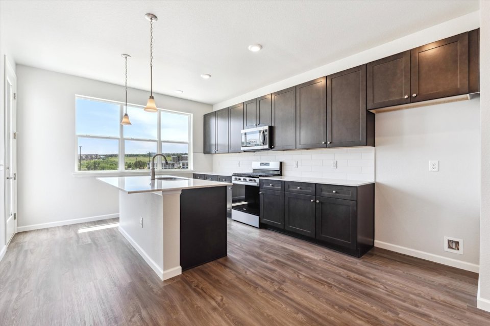 A kitchen with black cabinets.