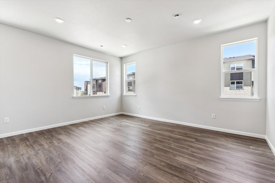 A room with a wood floor and windows.