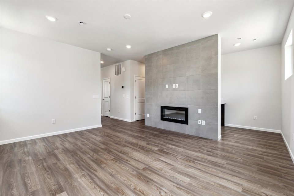 A room with a fireplace and a wood floor.