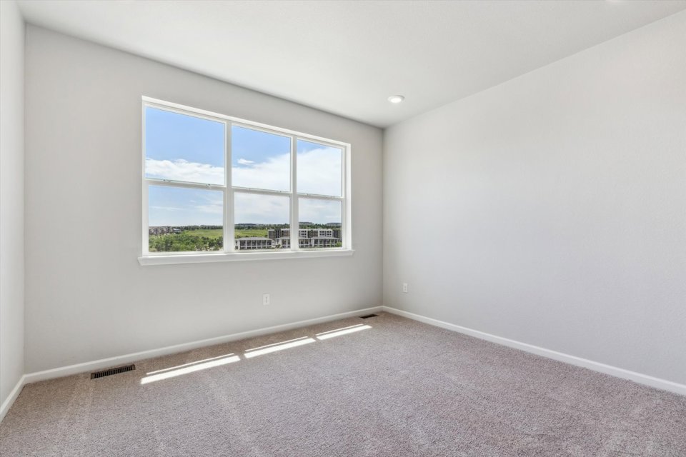 A room with a window and a carpet.