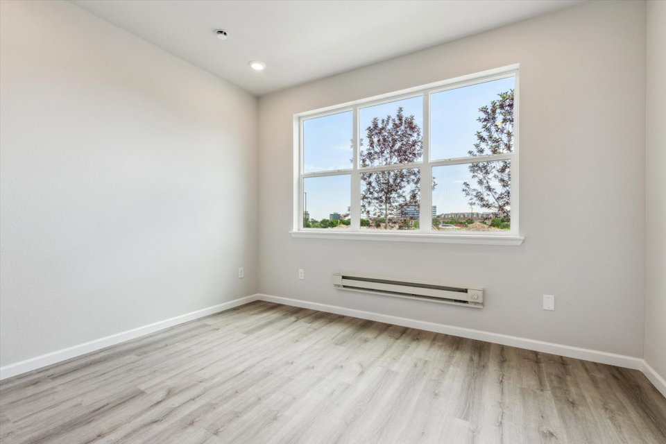 A room with a window and a wood floor.