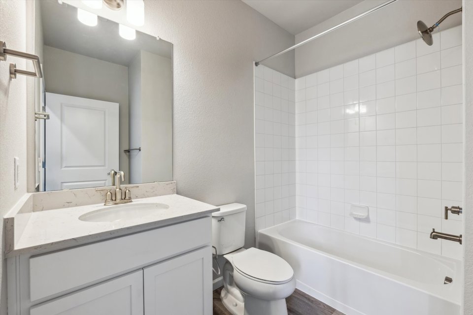 A bathroom with a tub sink and toilet.