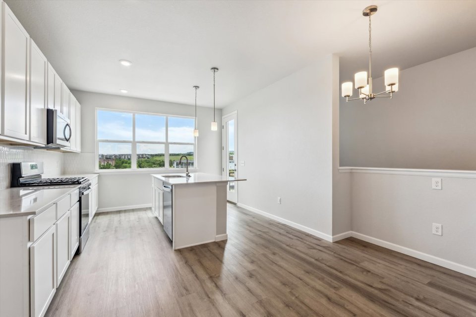 A kitchen with white cabinets.