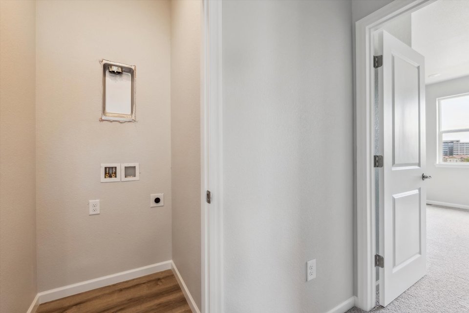 A white room with a mirror and a door.