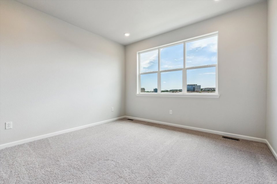 A room with a window and a white wall.