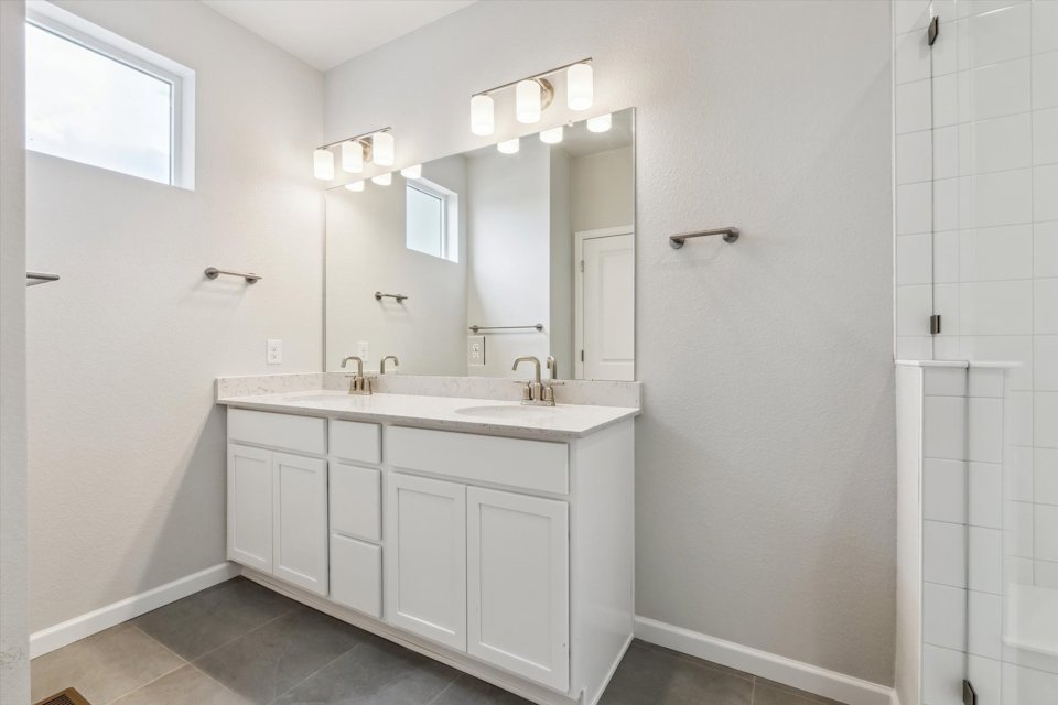 A bathroom with white cabinets.