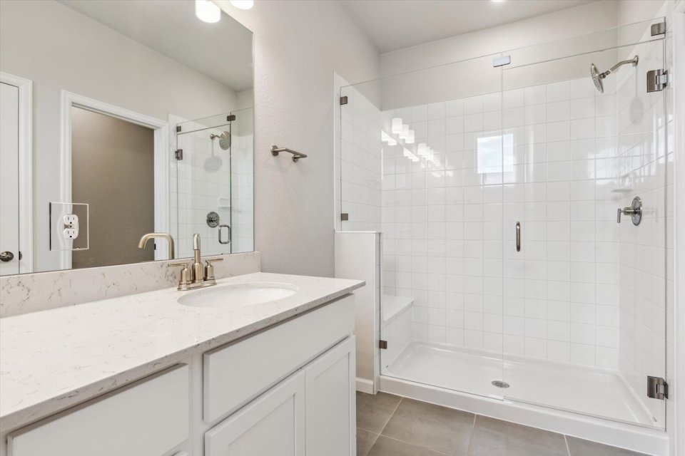 A bathroom with a shower and sink.