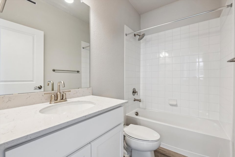A bathroom with a tub sink and toilet.
