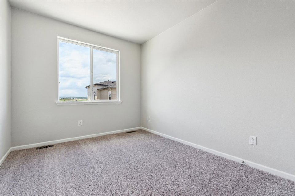 A room with a window and a carpet.