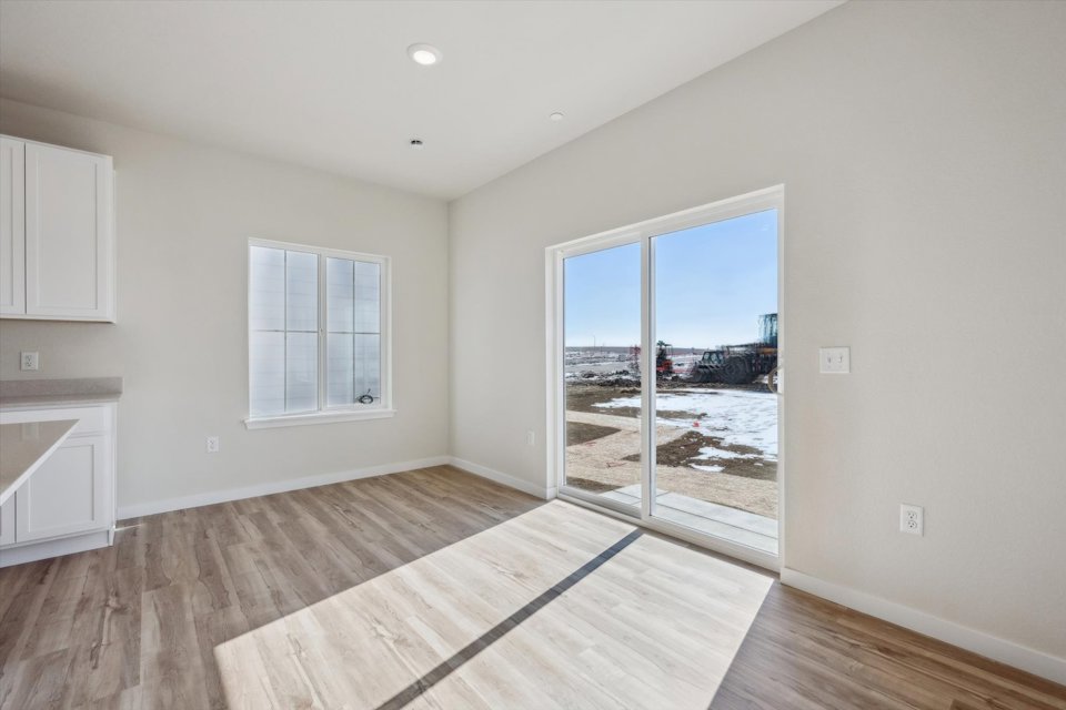 A room with a wood floor and a large window.