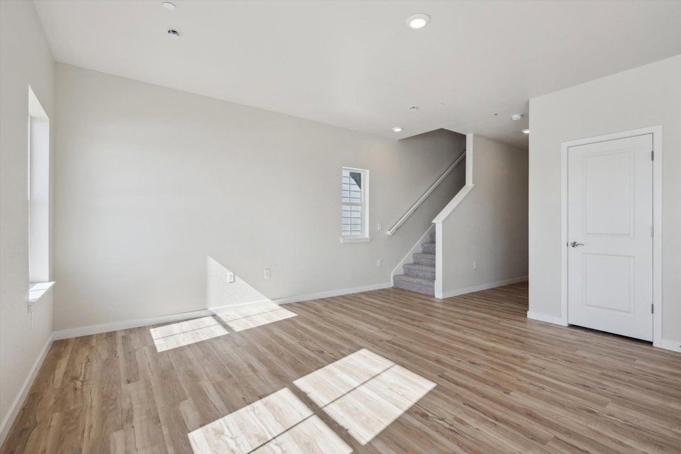 A room with a wood floor and white walls.