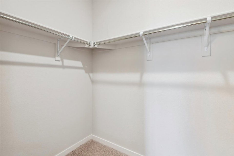 A white wall with a metal bar.