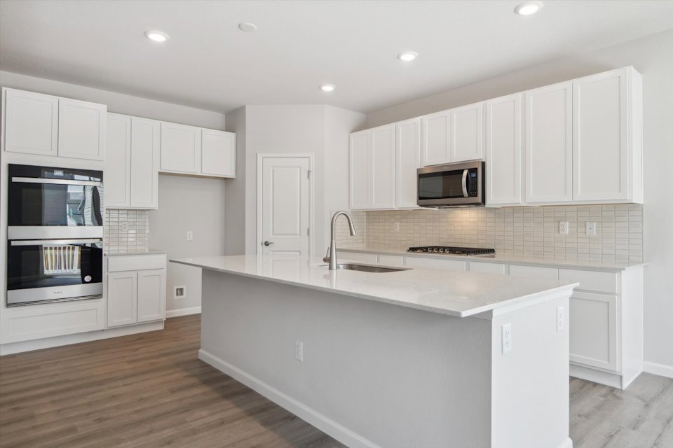 A kitchen with white cabinets.