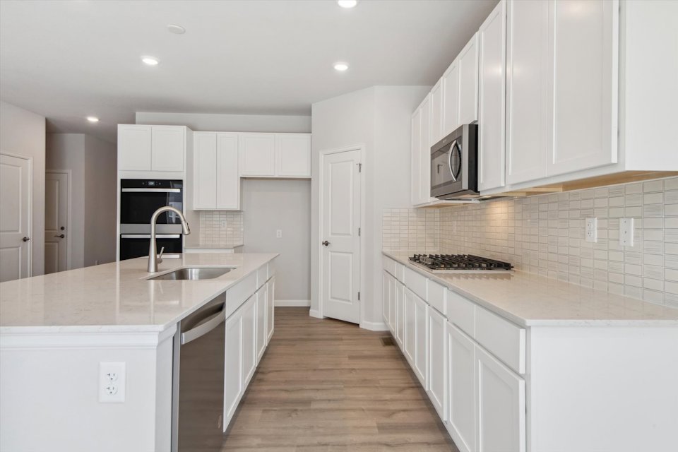 A kitchen with white cabinets.