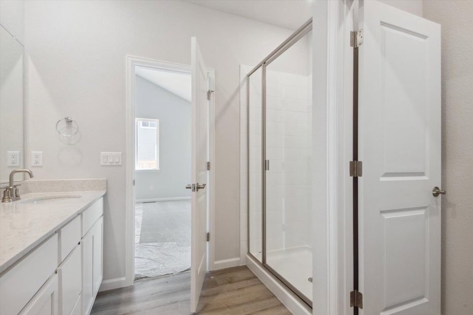 A bathroom with a shower and a glass door.