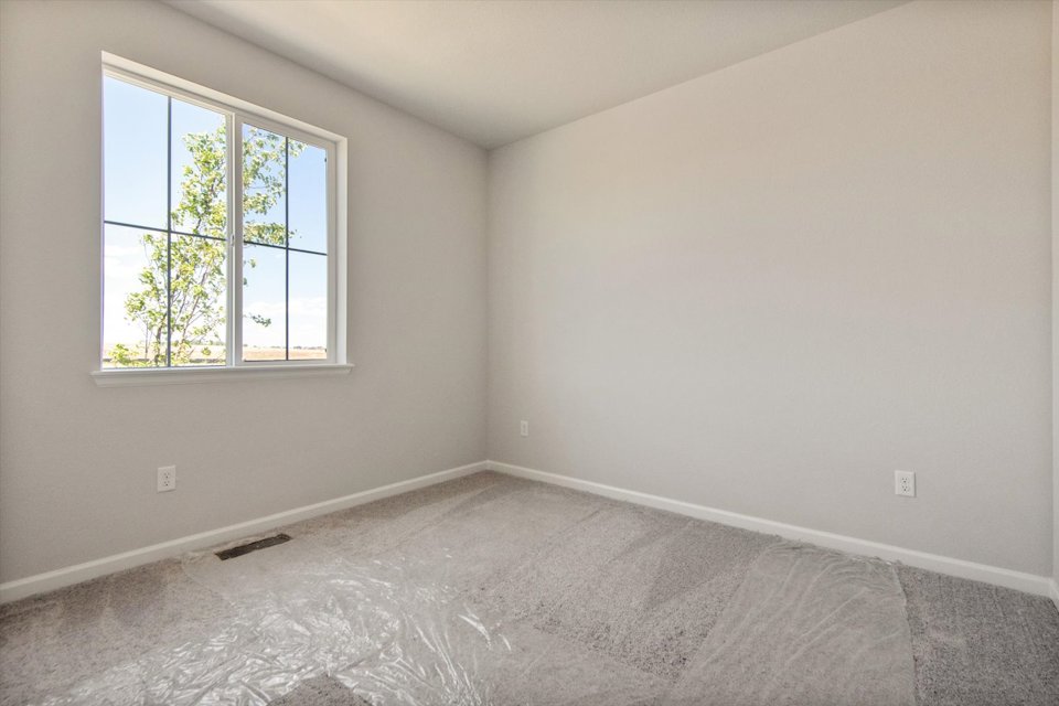 A room with a window and a rug in it.