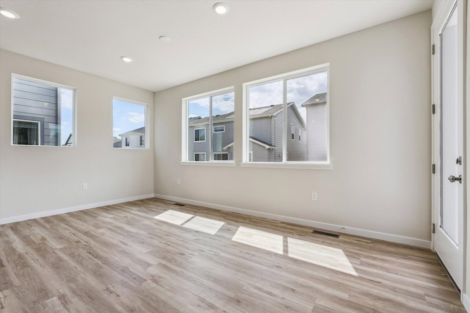 A room with a wood floor and a wood floor with a window.