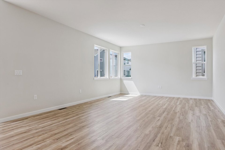 A room with a wood floor and windows.