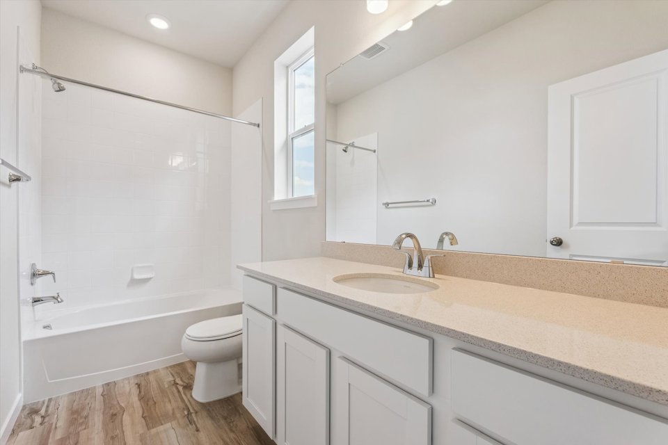 A bathroom with a tub sink and toilet.