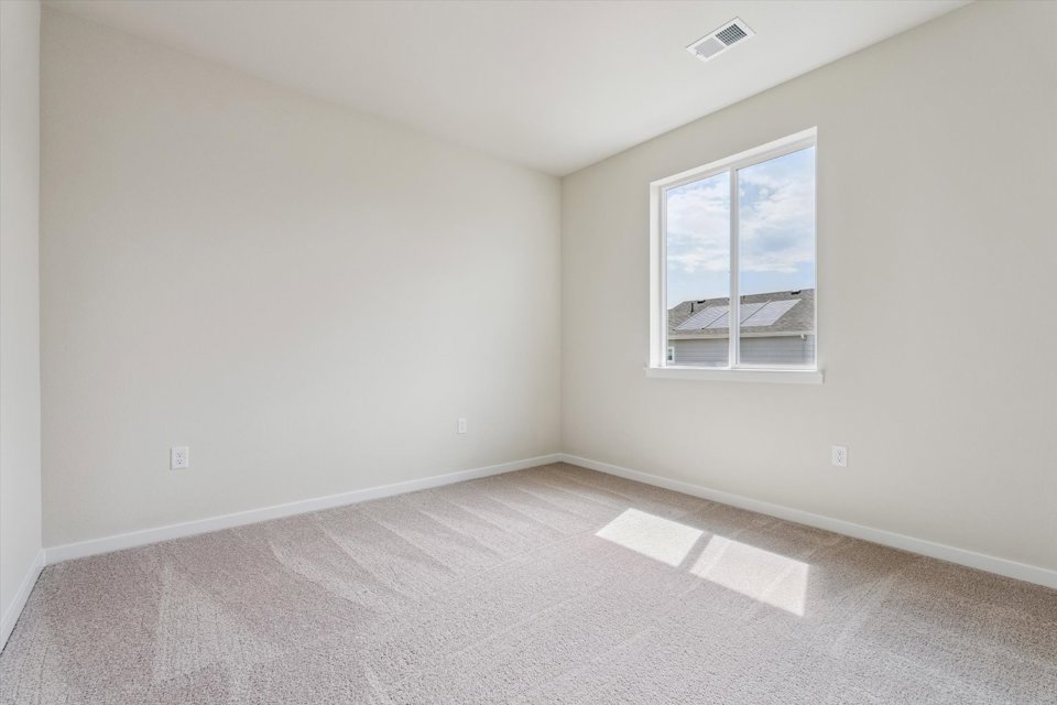 A room with a window and a carpet.