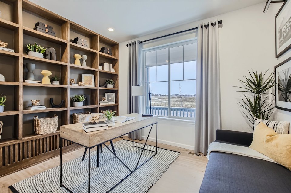 A room with a table and a bookcase with a window.