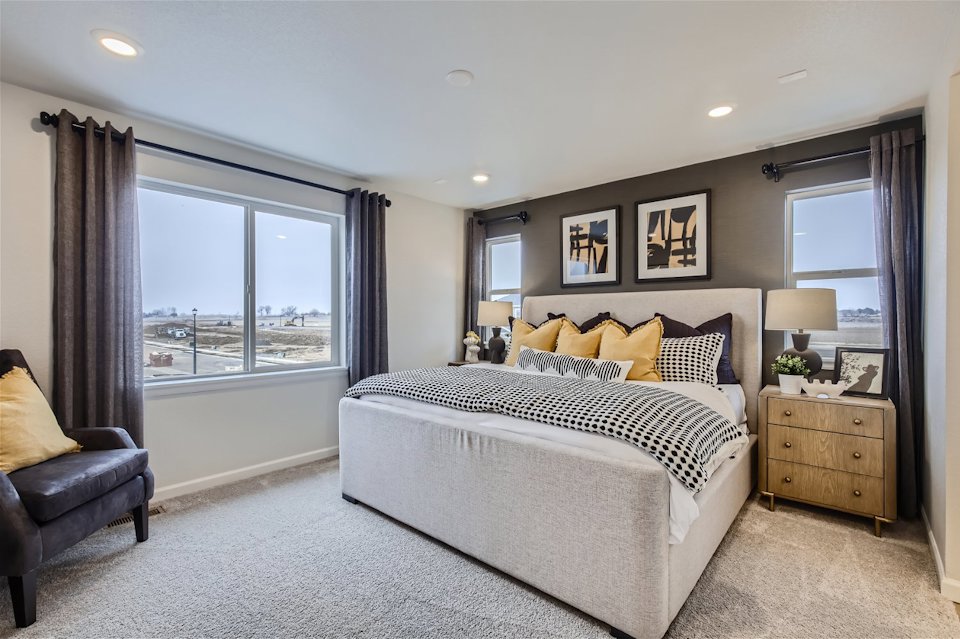 A bedroom with a large window.