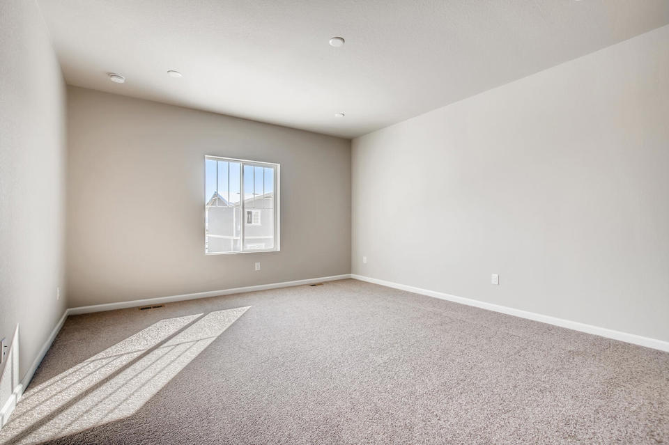 A room with a rug and a window.
