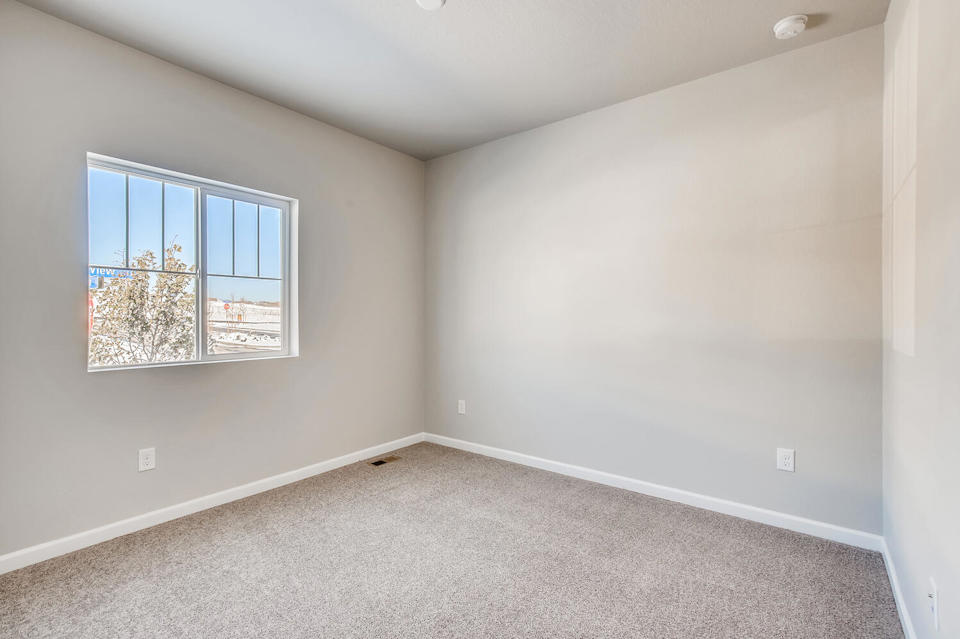 A room with a window and a carpet.