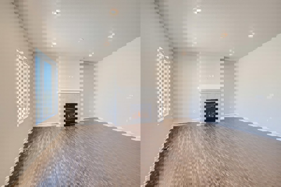 A room with a fireplace and wood floors.