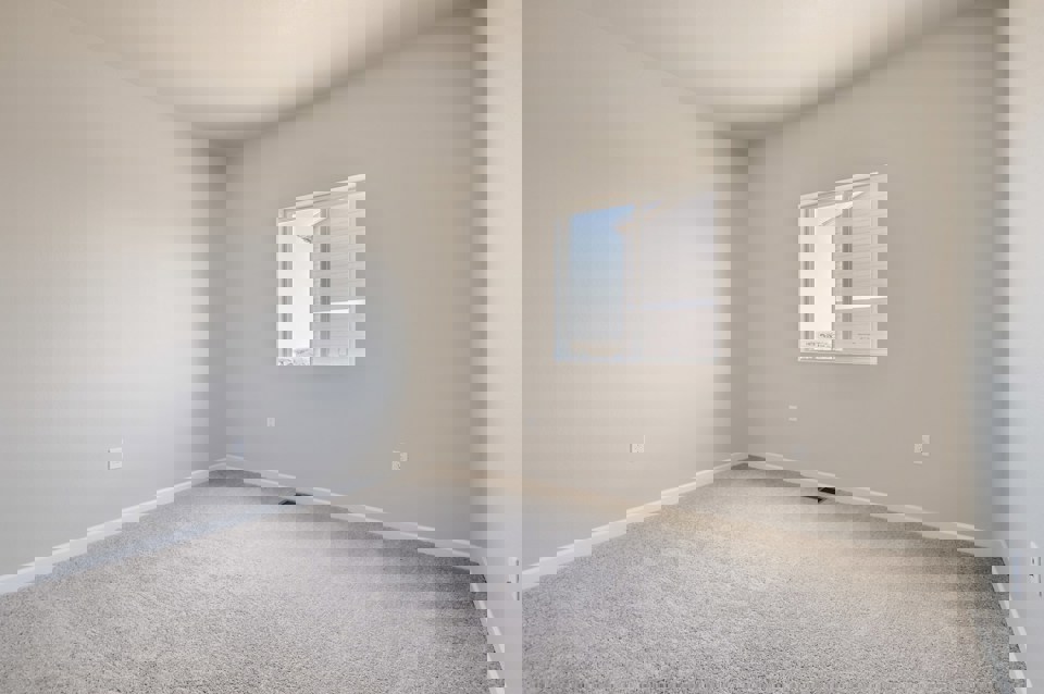 A room with a window and carpet.