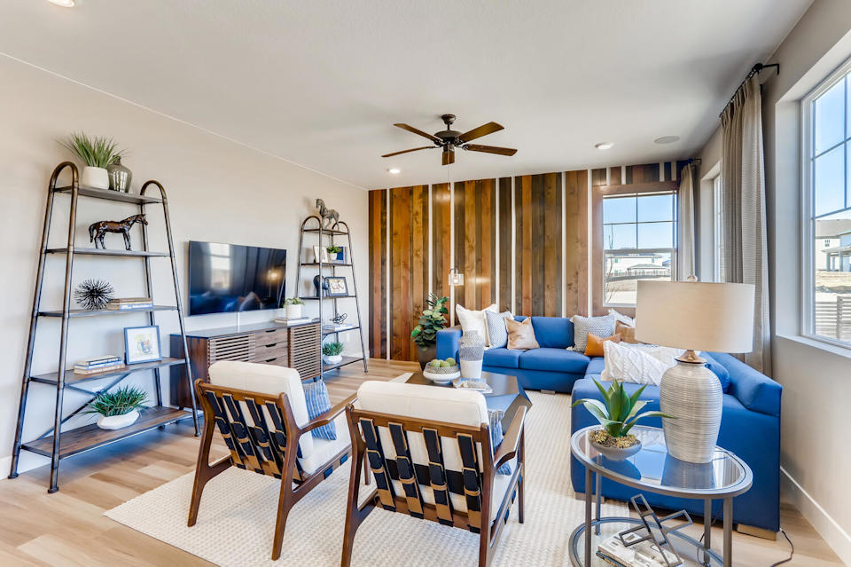 A living room with a blue couch and a table.