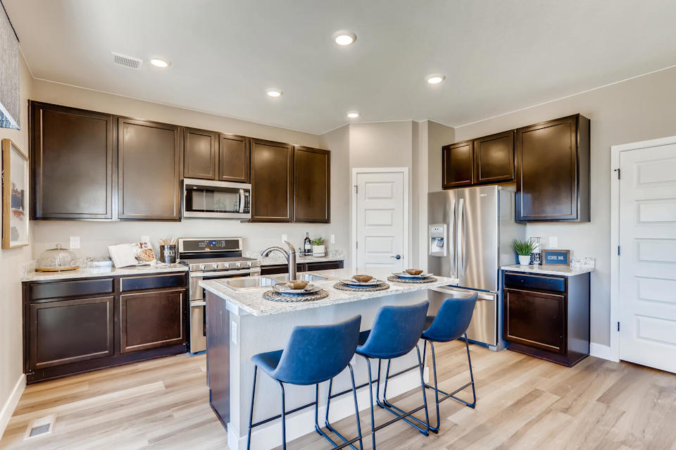 A kitchen with a dining table and chairs.